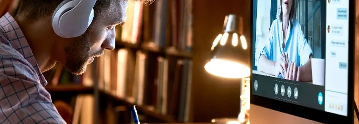 Person mit Kopfhörer schreibt in Notizbuch